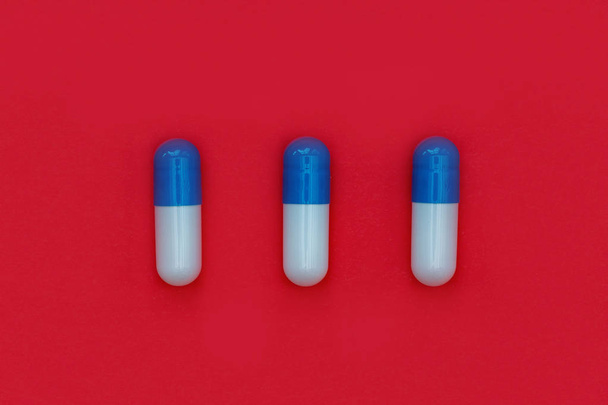 close-up view of row of pills on bright red background  - Foto, afbeelding