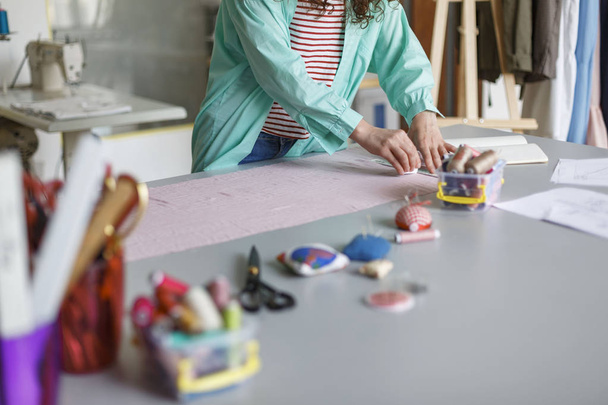 Cerca de dibujo de diseño joven con jabón en textil rosa en acogedor taller de costura
 - Foto, Imagen