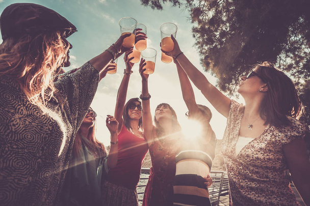 groupe de femmes célébrant l'amitié ou le succès avec des cocktails à l'orange
  - Photo, image