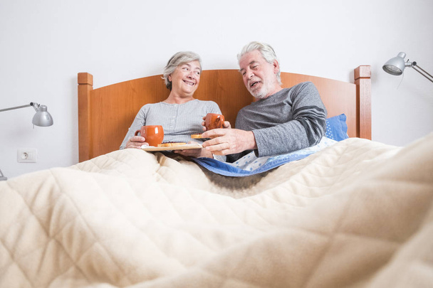ηλικίας ζευγάρι κατοχής του προγεύματος στο κρεβάτι στο σπίτι  - Φωτογραφία, εικόνα