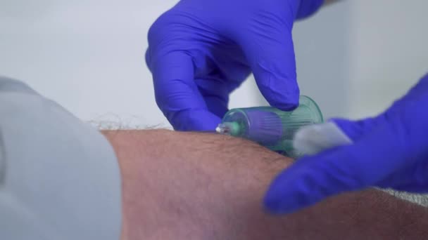 Nurse taking blood from a vein of senior man - Video, Çekim