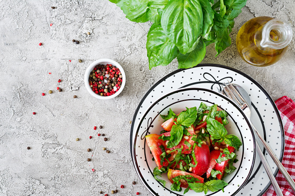 Ensalada de tomate con albahaca y piñones en tazón - dieta vegetariana saludable aperitivo de alimentos orgánicos. Vista superior. Puesta plana
 - Foto, Imagen