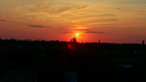 beautiful small red sun get down against red sky in city landscape at sunset - Footage, Video