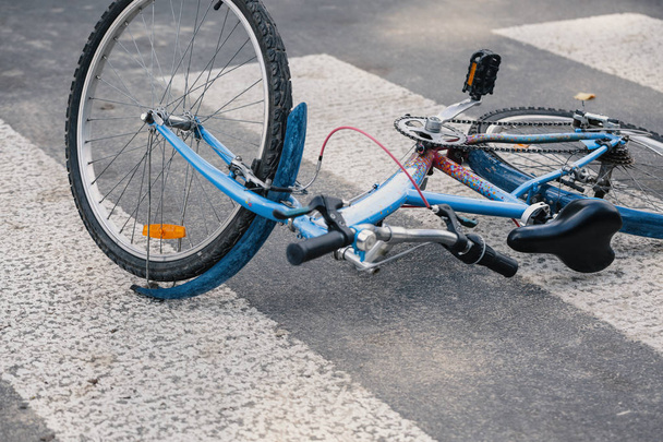 Blue child's bicycle lying on a pedestrian crossing after a traffic accident - Photo, image