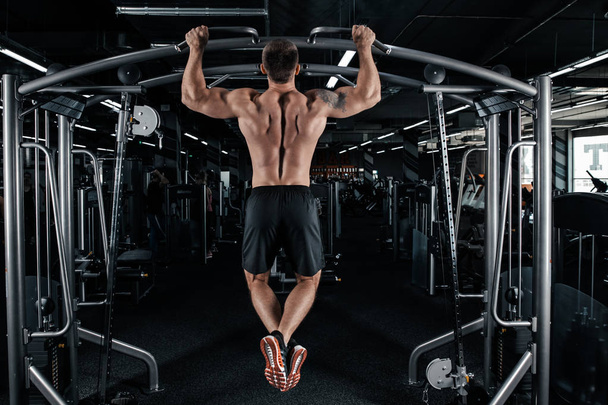 Vista posteriore di uomo muscolare facendo tirare su esercizio - Foto, immagini