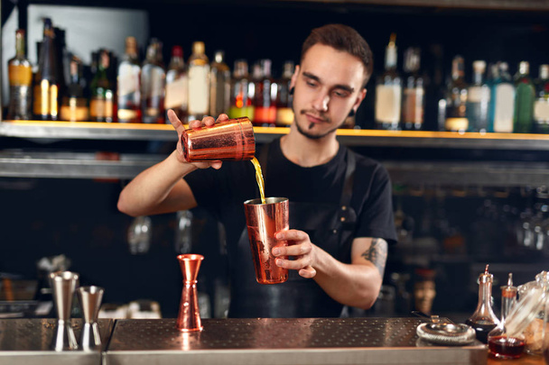 Cocktail Bar. Bartender Making Cocktails At Bar Counter. Barman Preparing Drink, Pouring Spirits In Shaker. High Resolution - Фото, зображення