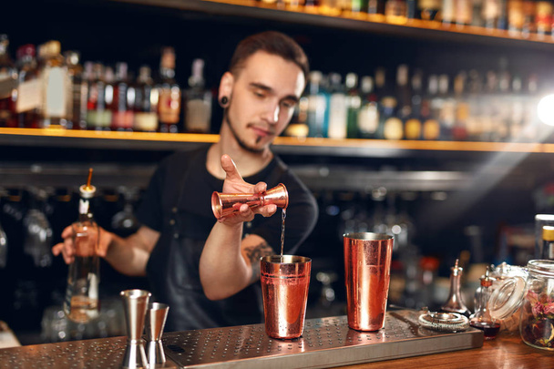 Cocktail. Bartender Making Cocktails in Bar. Barman Making Drinks Using Jigger And Shaker At Bar Counter. High Resolution - 写真・画像