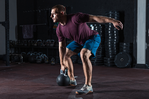 Young muscular man training with kettlebells. Strength and motivation - Photo, Image