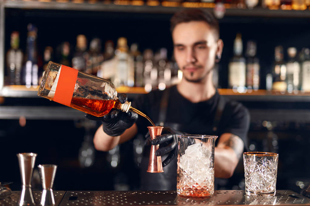 Bar. Bartender Making Cocktails, Measuring Alcohol From Bottle Into Jigger, Mixing Spirits With Cocktail Shaker. High Resolution - Фото, зображення