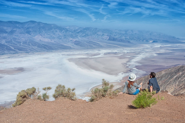 Pareja turística disfrutando del paisaje desértico de Badwater en el Parque Nacional del Valle de la Muerte, California, Estados Unidos
. - Foto, Imagen
