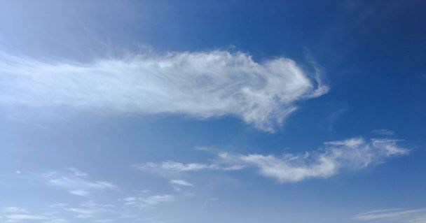 Prachtige wolken tegen de achtergrond van een blauwe hemel. Cloudscape hemel. Blauwe hemel met bewolkt weer, natuur wolk. Witte wolken, blauwe lucht en zon. - Foto, afbeelding