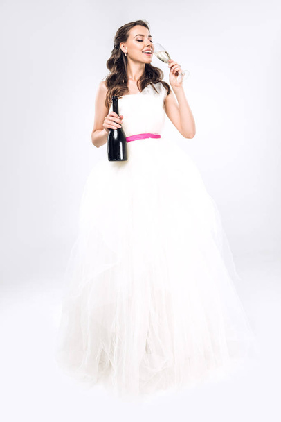 joven novia en vestido de novia beber champán en blanco
 - Foto, Imagen