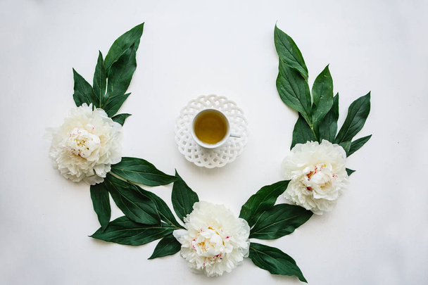 View from above. Fresh fragrant and healthy herbal or green tea in a mug. White flowers are nearby - Photo, Image