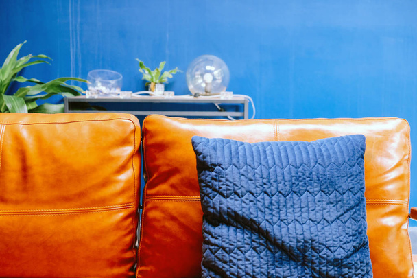 Détail rapproché de l'oreiller bleu sur le canapé en cuir
 - Photo, image