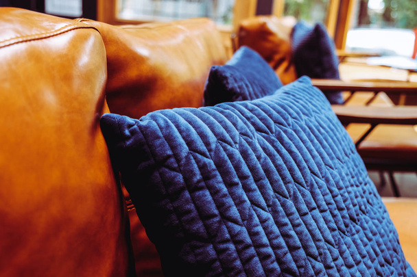 Dettaglio da vicino del cuscino blu sul divano in pelle
 - Foto, immagini