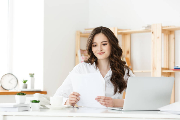 Happy young business woman or secretary holding document in modern office - Valokuva, kuva