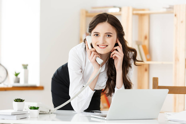Happy young business woman or secretary holding document in modern office - Foto, Imagen