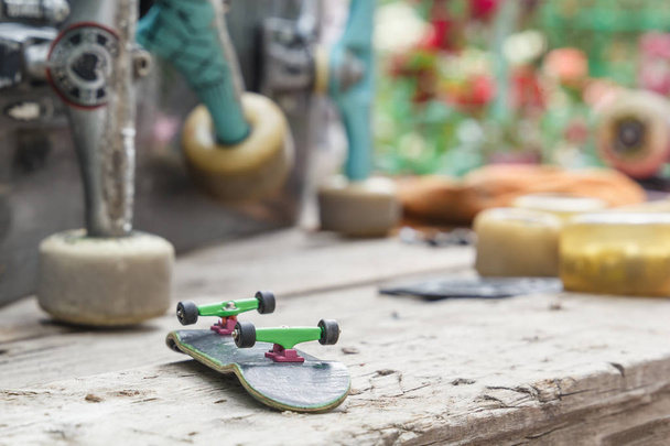 Skateboard jouet avec roues se trouve sur le fond d'une grande vieille planche à roulettes en attente de réparation sur une table en bois à l'extérieur. Espace de copie
 - Photo, image