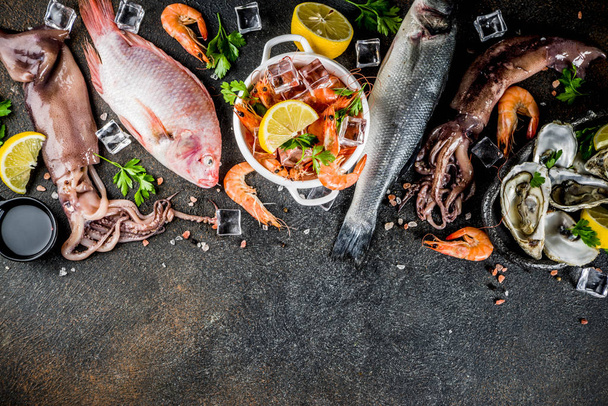 frische rohe Meeresfrüchte Tintenfisch Garnelen Austernmuscheln Fisch mit Gewürzen von Kräutern Zitrone auf dunklem rostigen Hintergrund kopieren Raum von oben - Foto, Bild