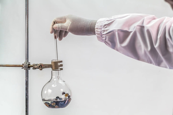 ένας επιστήμονας στο εργαστήριο απόσταξη της αλκοόλης από Blueberry εξοπλισμού διύλισης - Φωτογραφία, εικόνα