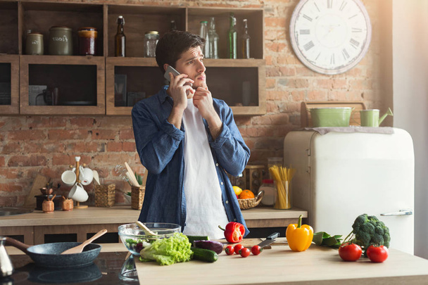 Disappointed man preparing healthy food in the home kitchen - Photo, Image