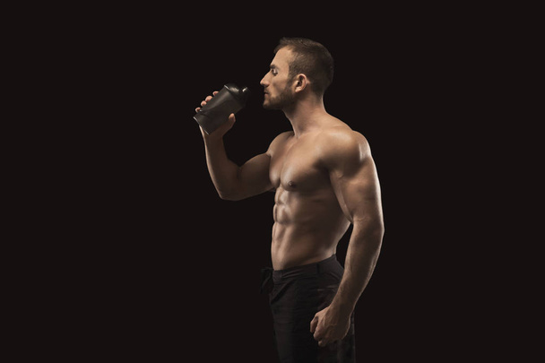 Male bodybuilder drinking water after workout - Photo, Image