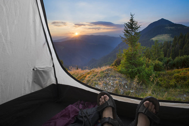 Two people lying in tent with a view of mountains - Fotografie, Obrázek
