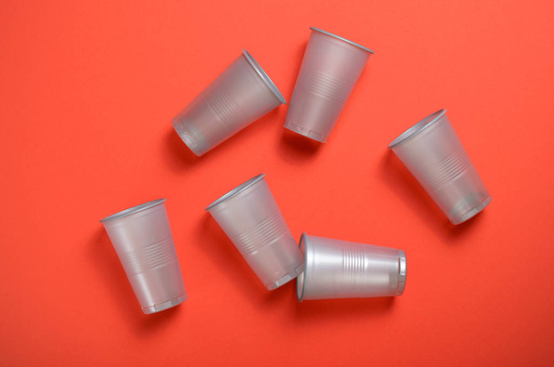Copas de plástico gris sobre fondo naranja brillante, Copas de plástico de un solo uso, Concepto de alimentos
 - Foto, imagen