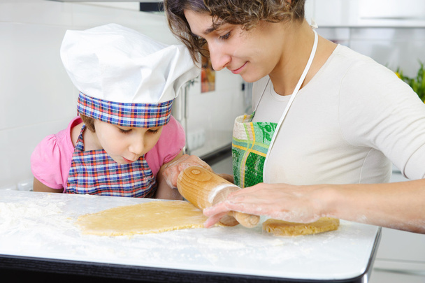 Young mother with little daughter preparing cookies - Fotoğraf, Görsel