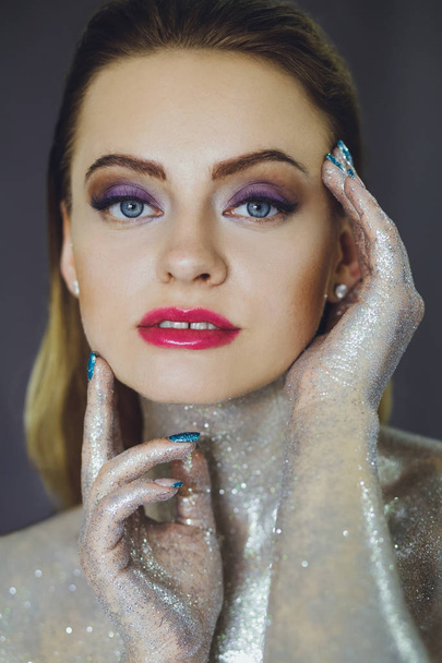 Beautiful girl with creative glitter makeup with sparkles. Beauty is an art face. Photo taken in the studio. - Foto, Imagen