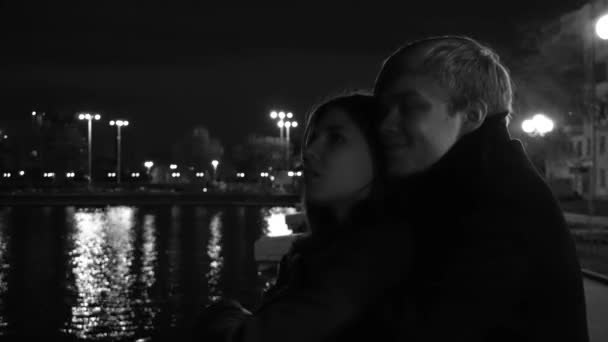 Young Couple Passionately Embracing on the City Street at Night. A young couple hug and kiss each other in a city Park. Close up shot. Young happy couple man and attractive girl walking down the night - Footage, Video