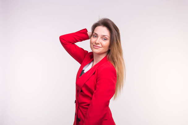 Elegante mujer europea en un jaket rojo con la mano en el pelo
 - Foto, Imagen