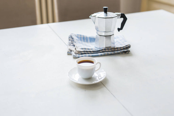 Tasse Kaffee, Wasserkocher auf weißem Tisch - Foto, Bild