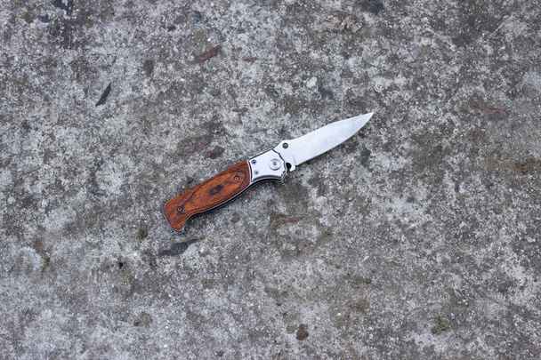 Folding knife on a concrete background - Fotó, kép
