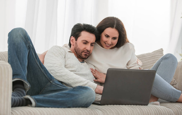 close up.a married couple sitting on the couch and looking at the laptop - Foto, Imagem