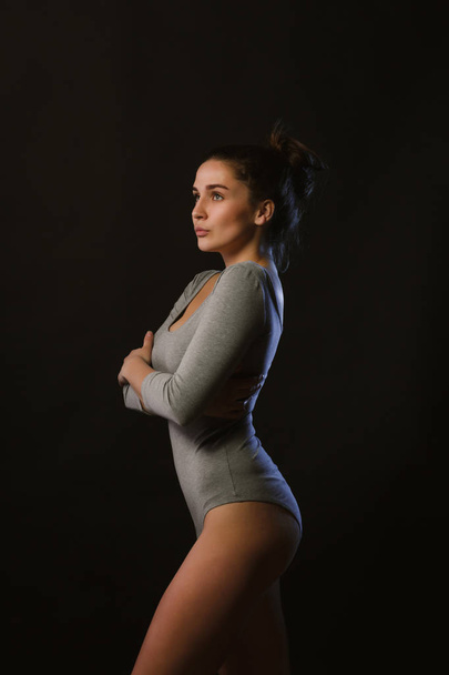 Modelo de concurso posando em estúdio durante teste padrão de tiro vestindo lingerie cinza
 - Foto, Imagem