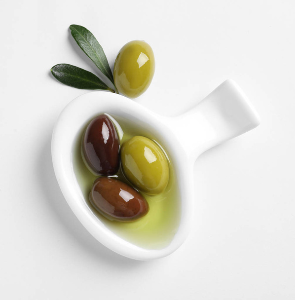 Bowl with fresh olives in oil on white background, top view - Valokuva, kuva