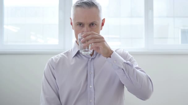 Biznesmen wody pitnej w biurze - Materiał filmowy, wideo