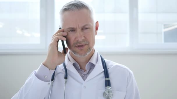 Lekarz omawia z pacjentem podczas rozmowy telefonicznej - Materiał filmowy, wideo
