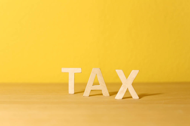 Word TAX on table against color background - Foto, afbeelding