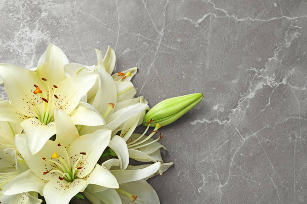 Flat lay composition with lily flowers on grey background - Foto, imagen