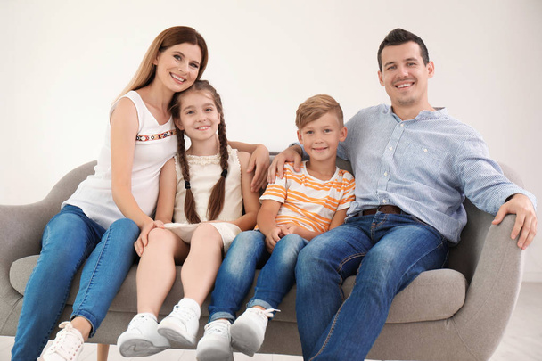 glückliche Familie mit niedlichen Kindern auf dem heimischen Sofa - Foto, Bild