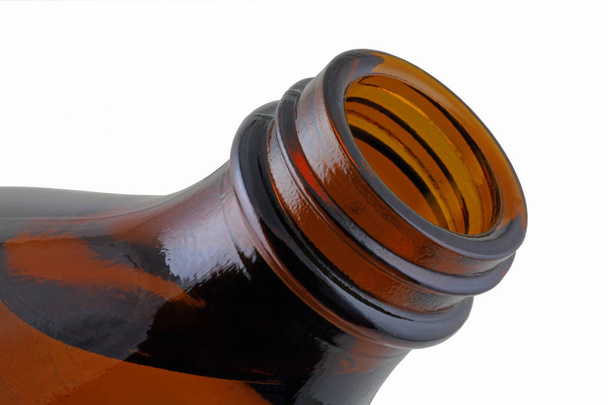 Brown  glass bottle -  A bottle containing fluid being tipped out isolated on a white background  - 写真・画像