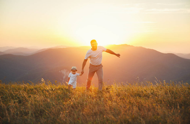 La fête des pères. Heureux père de famille et fils en bas âge jouer et rire sur la nature au coucher du soleil
 - Photo, image