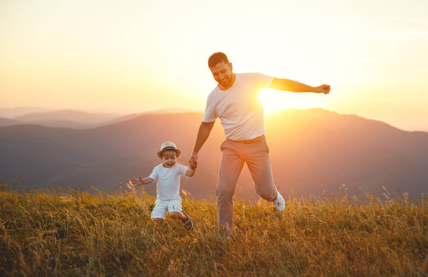 Isänpäivä. Onnellinen perhe isä ja lapsi poika leikkii ja nauraa luonnon auringonlaskun aikaan
 - Valokuva, kuva