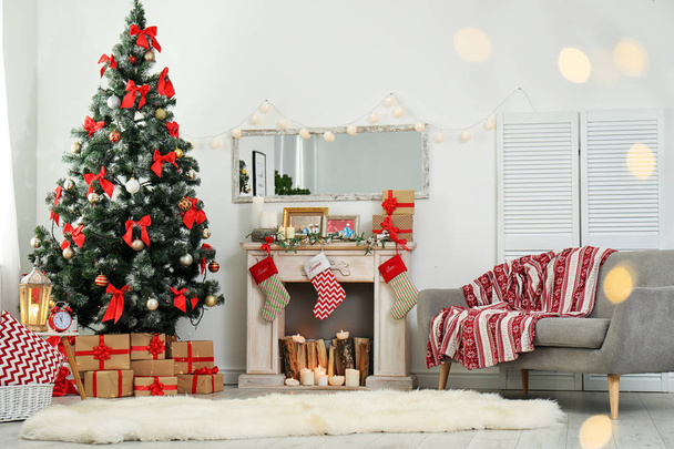 Stylish living room interior with decorated Christmas tree and blurred lights in foreground - 写真・画像