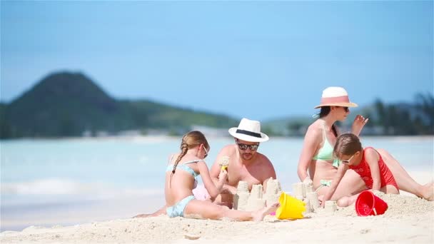 Rodziny podejmowania zamek z piasku na plaży biały na letnie wakacje - Materiał filmowy, wideo
