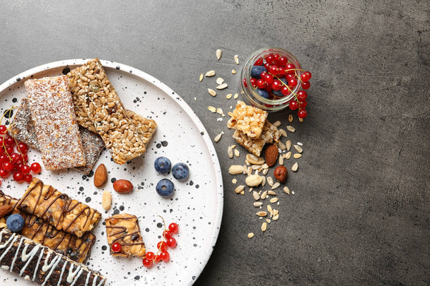 Plate with different grain cereal bars on table, top view. Healthy snack - Foto, imagen