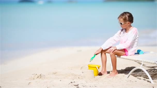 Schattig klein meisje spelen met speelgoed op strand vakantie. - Video