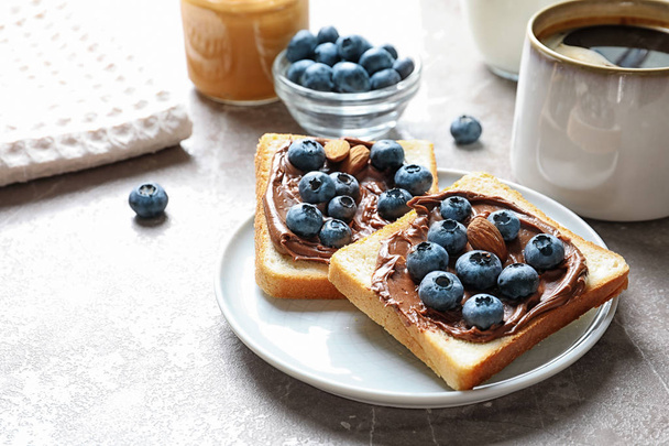Toast bread with blueberries and chocolate paste on table - Fotografie, Obrázek